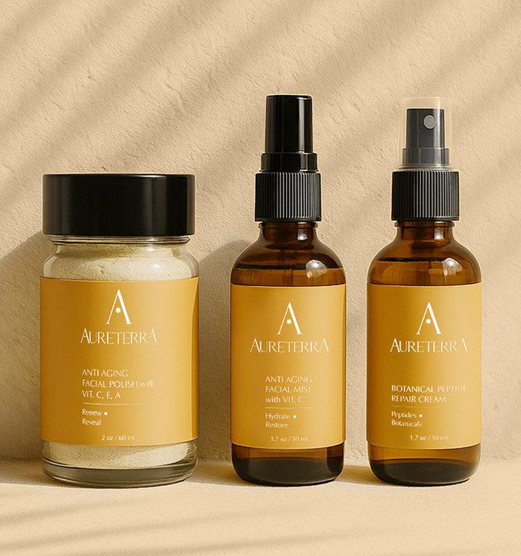 Aureterra Glow Starter Kit with Botanical Peptide Cream, Anti-Aging Facial Polish, and Vitamin C Mist on a neutral sunlit background.